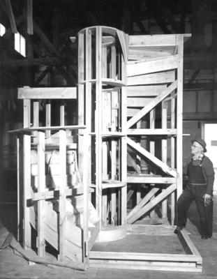 Wooden spiral staircase (Littlejohns) man standing next to the framework of the stairs