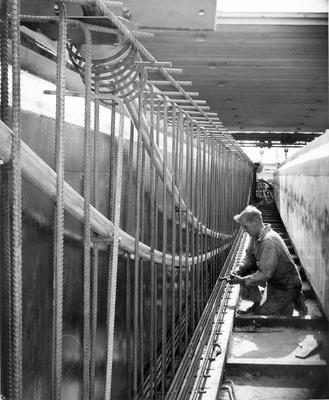 Certified Concrete Ltd - Blenheim Rd plant, Christchurch: 1959 man working on machinery; Circa 1959; Photograph